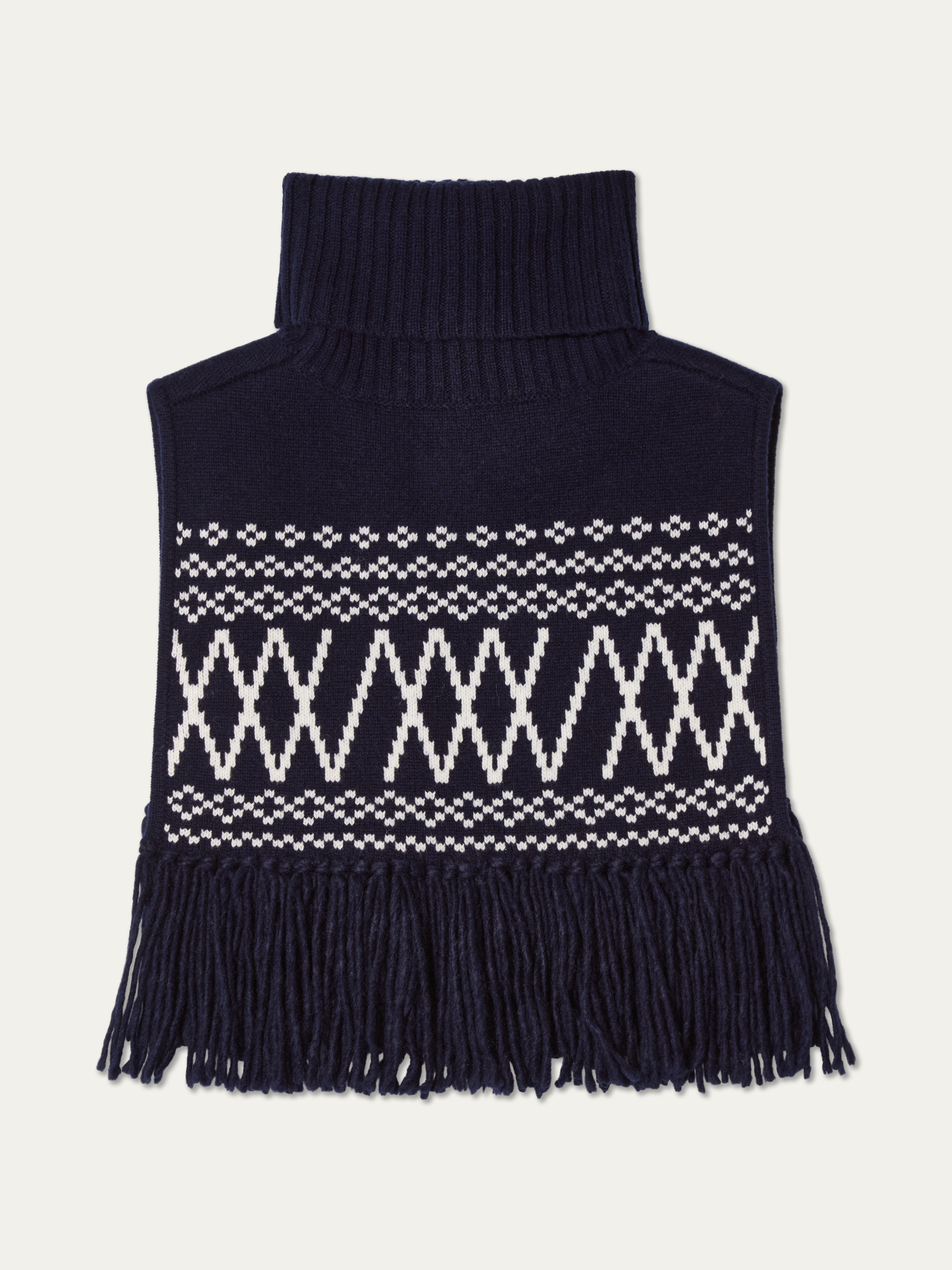 We Norwegians | FW25 | Setesdal Bib_Navy blue | A knitted bib with a turtle neck and fine fringes at the hem against an off-white background