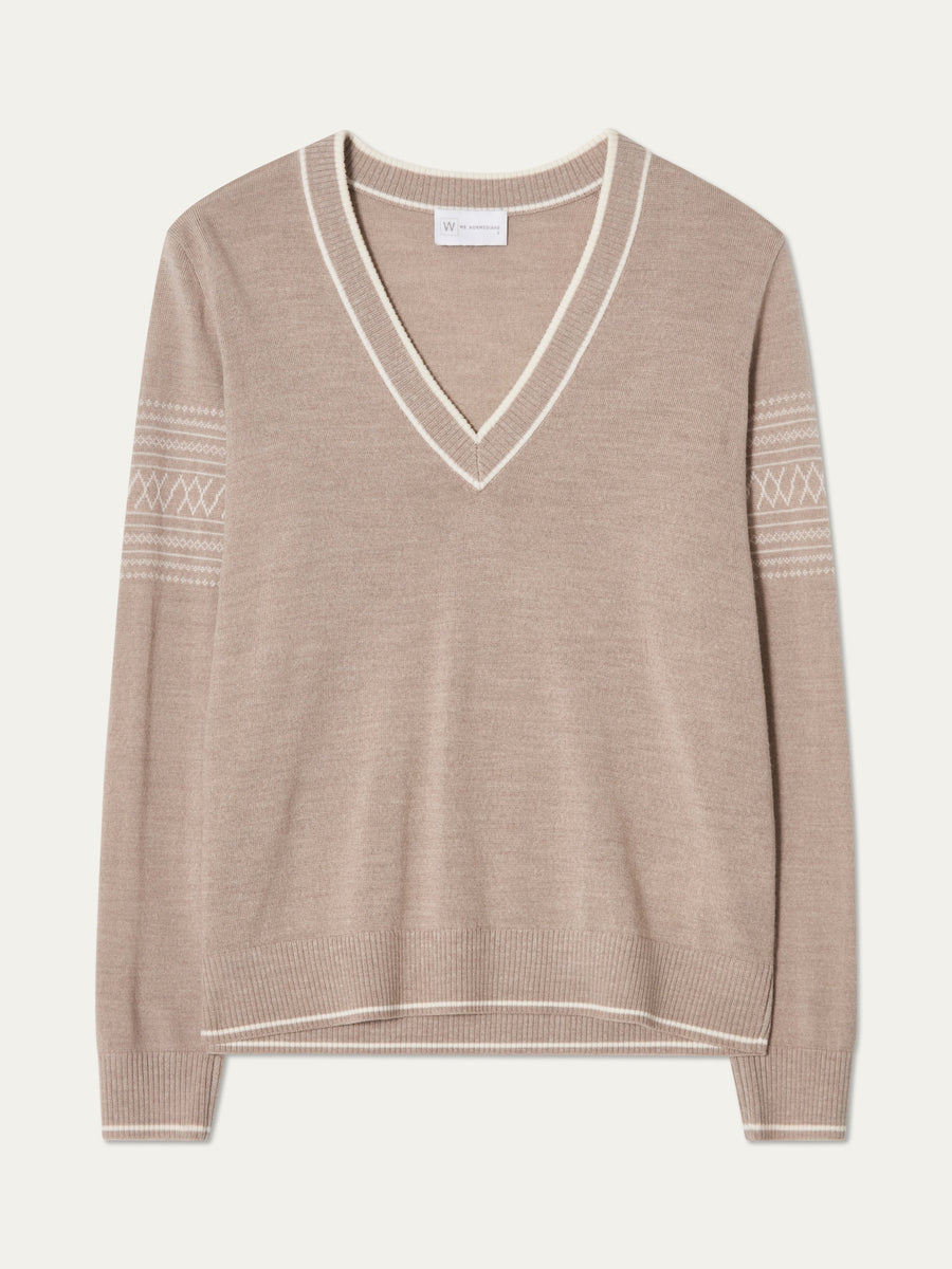 We Norwegians | FW25 | Womens Signature V-neck Sweater_Sand | A fine knitted sweater with white edges on the neckline, sleeves and hemline, with the signature setesdal pattern on the sleeves | Shot against an off-white background