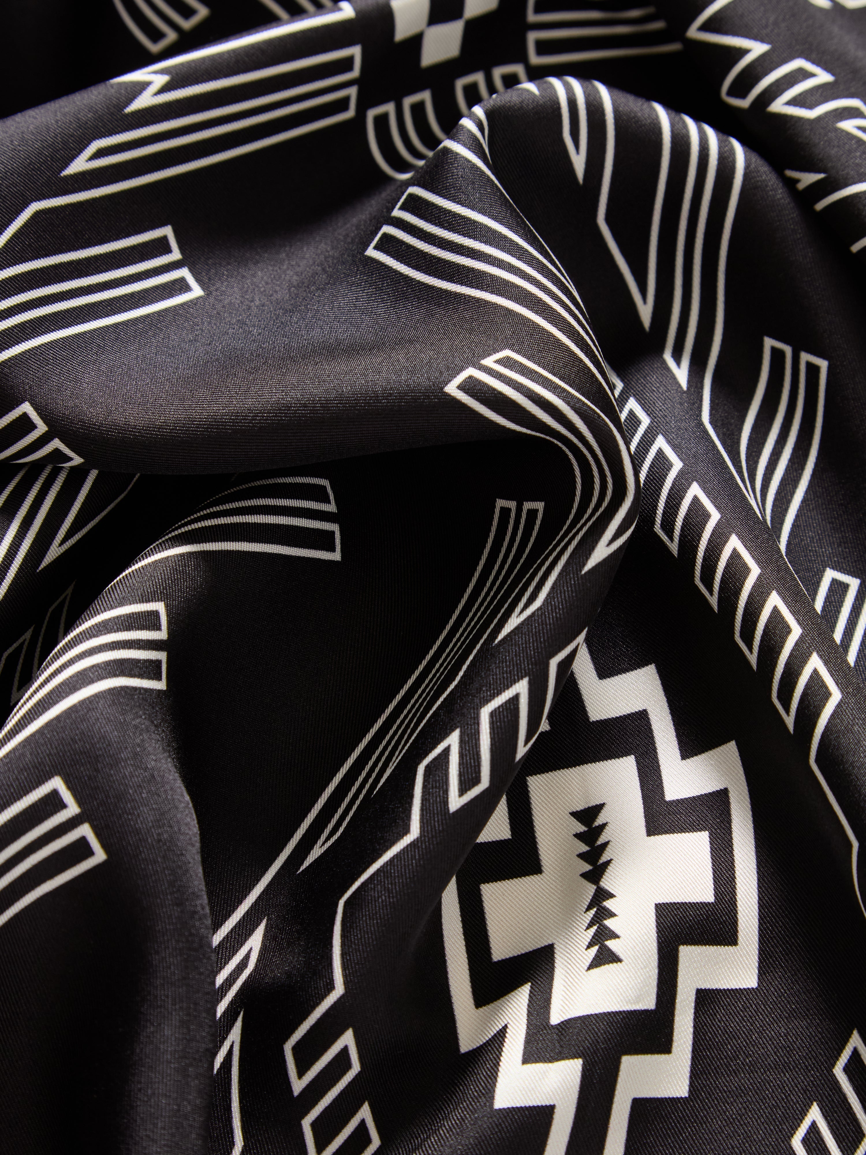 We Norwegians | FW25 | Pioneer Silk Scarf_Black | Scarf with printed motifs | Photograph showing the fabric and print details